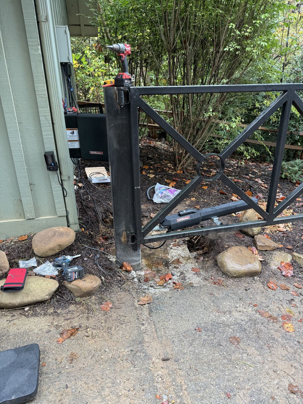 Decorative metal swing gate with LiftMaster operator arm during installation