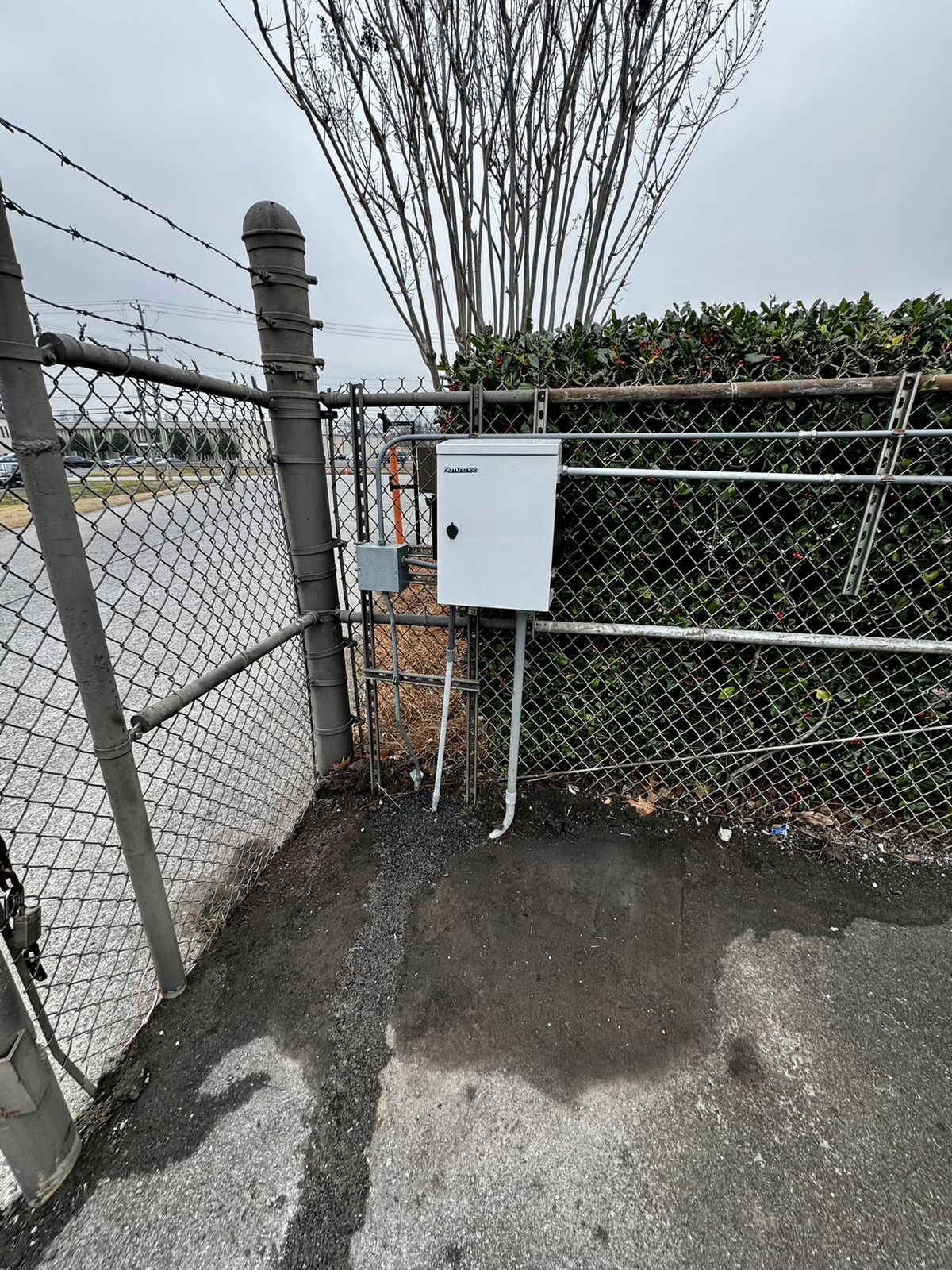 Fence-mounted outdoor weatherproof enclosure with neat conduit runs